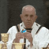 a man in a white robe is holding a blue and white ball with a penguin on it