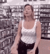 a woman is standing in a store with her hands outstretched .