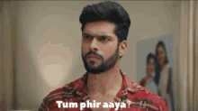 a man with a beard is looking at the camera with the words tumphir aaya written above him .