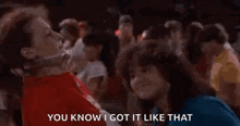 a crowd of people are dancing in a club and a woman is talking to a man in a red shirt .