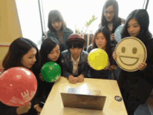 a group of girls are holding balloons and a sign that says smiley face