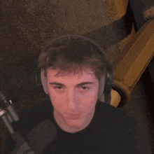 a young man wearing headphones is making a funny face .