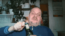 a man with a beard is opening a bottle of beer with a bottle opener