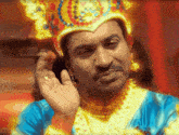 a man wearing a crown and a blue and gold outfit