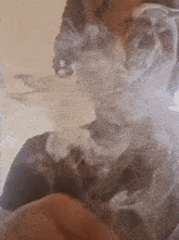 a close up of a person smoking a cigarette with smoke coming out of their mouth .