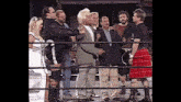 a man in a kilt is standing in a wrestling ring with other men