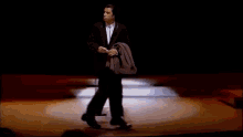 a man in a suit and tie is standing on a stage .
