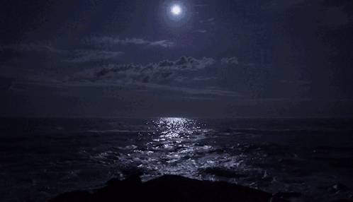 full moon over a dark ocean