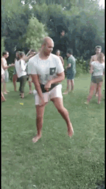 a man in a white shirt and shorts is jumping in the air