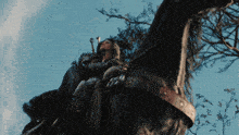 a woman is riding a black horse with a sword on her back