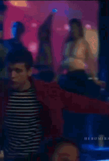 a blurry picture of a man in a red jacket and striped shirt