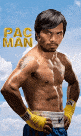 a shirtless boxer stands with his hands on his hips in front of a pac man balloon