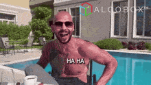 a shirtless man is laughing in front of a swimming pool with a logo for algobox