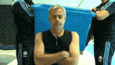 a man with his arms crossed wears a black tank top with a samsung logo on it