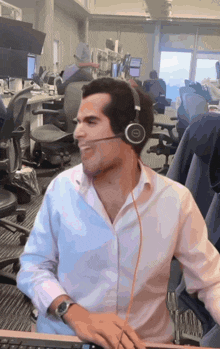 a man wearing a headset with a dell logo on it sits at a desk