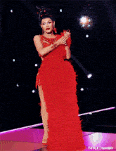 a woman in a red dress is dancing on a stage ..