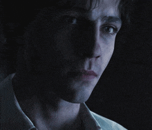 a man 's face is shown in a dark room