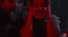 a man is holding a woman 's head while she cries