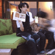 a man sitting on a couch reading a book
