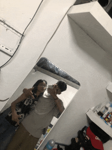 a man and woman are taking a picture in a mirror
