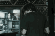 a man in a black t-shirt is looking down