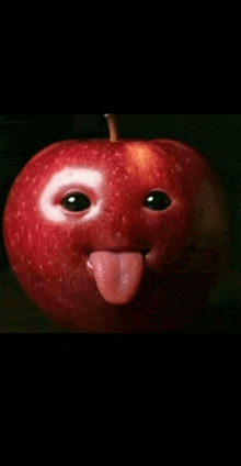 a red apple with a face carved into it sticking out its tongue