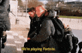 a group of people are playing a video game and one of them says we 're playing fortnite