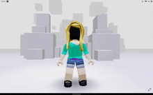 a girl in a blue shirt and shorts is standing in front of a stack of boxes