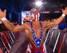 a wrestler wearing a red white and blue outfit with stars and a mask