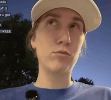 a woman wearing a baseball cap and a blue shirt looks up