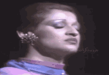 a close up of a woman 's face with arabic writing in the corner
