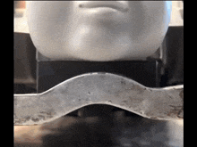 a statue of a man 's face is sitting on a metal bar