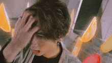 a close up of a person 's face with a hand on their forehead