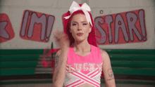 a cheerleader in front of a wall that says i 'm a star
