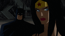 batman and wonder woman are standing next to each other in a dark room
