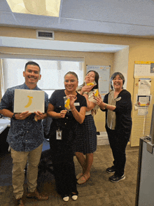 a group of people holding bananas in front of a white board that says " start & finish " on it