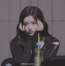 a woman sitting in front of a bottle of water with a yellow straw and the words oldman sunny on the bottom