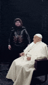 a man with a beard is standing next to a man in a white robe