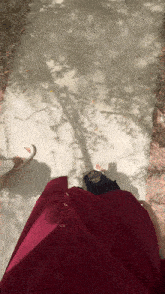 a person in a red dress is standing on a sidewalk