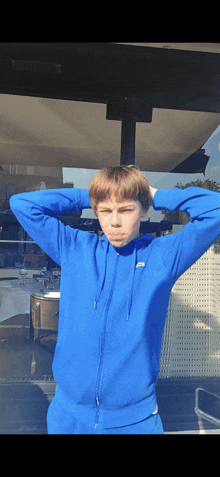 a young man wearing a blue lacoste hoodie