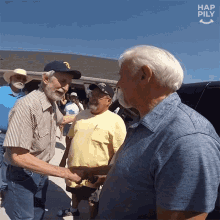 a group of men are shaking hands in front of a sign that says hap pily on it