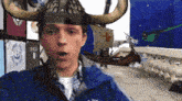 a man wearing a viking helmet with horns and a blue jacket