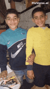 two boys are posing for a photo and one has a nike shirt on
