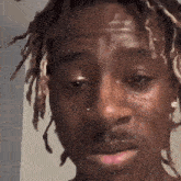 a close up of a man 's face with a tear running down his face .