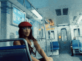 a woman wearing a red hat sits on a train