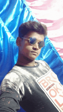 a young man wearing sunglasses and a brooklyn shirt