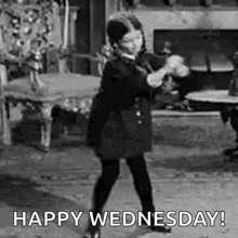 a black and white photo of a little girl dancing in a room .
