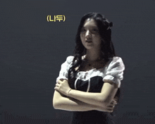 a woman in a black and white dress is dancing in front of a yellow sign that says ( n )