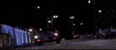 a man wearing a bandana and a hat is sitting in a car at night .
