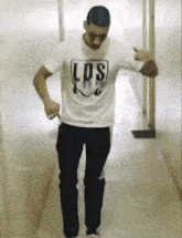 a man wearing a los angeles t-shirt is dancing in a hallway